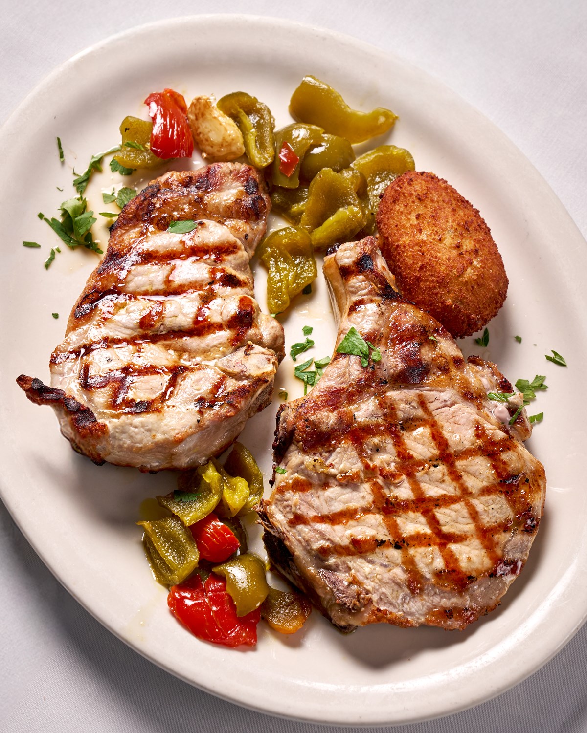 Grilled pork chop served at Casa Bella with cherry peppers.